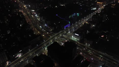 Rajkot-aerial-drone-view-Drone-camera-is-moving-upwards-where-many-vehicles-are-passing-by-and-many-vehicles-are-passing-under-the-flower-with-bikes-and-four-wheels-also-visible