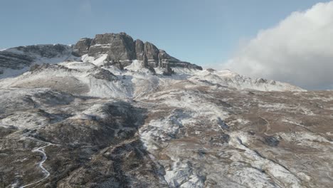 The-old-man-of-storr-rock-formation-on-the-isle-of-skye,-scotland,-with-light-snow-cover,-aerial-view