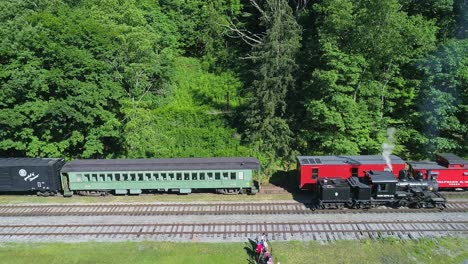 Luftaufnahme-Einer-Antiken-Shay-Dampflokomotive,-Die-An-Einem-Sonnigen-Sommermorgen-In-Zeitlupe-Rückwärts-Fährt,-Um-Sich-Einem-Bahnhof-Zu-Nähern