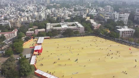 Luftaufnahme-Einer-Drohne-Beim-Rajkot-Kite-Festival.-Die-Kamera-Bewegt-Sich-Von-Der-Seite-Des-Großen-Drachens,-An-Dem-Viele-Verschiedene-Arten-Großer-Drachen-Fliegen.