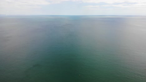 Forward-aerial-shot-of-a-turquiose-sea-off-the-coast-at-Sandbanks-Dorset-England