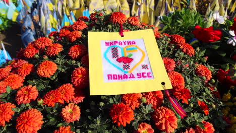 Khreshchatyk-street-with-red-flowers-and-Ukrainian-memorial-flags-with-names-of-fallen-soldiers-in-Kyiv-Ukraine,-honor-for-the-soldiers-who-died-during-the-Russia-Ukraine-war,-honoring-remembering,-4K