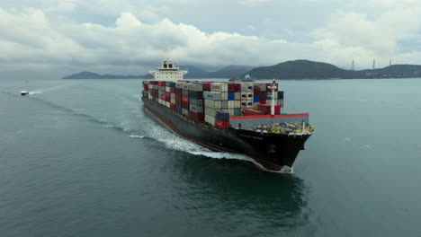 Fast-fly-by-in-front-of-the-bow-of-a-large-container-ship---drone-shot