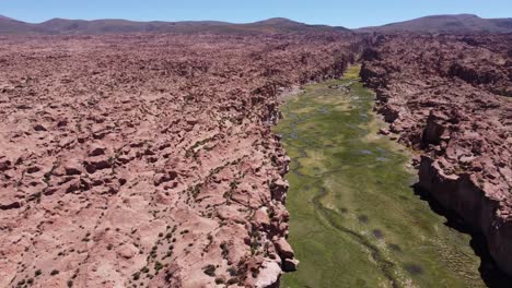 Bolivia-altiplano-rugged-landscape,-aerial-flyover-hidden-green-valley