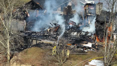 Feuerwehrleute-Sprühen-Wasser-Mit-Schlauch-Auf-Bauernhaus-Während-Feuer