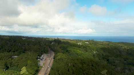 Aerial-descending-shot-of-Twin-Falls-Maui-Waterfall-Parking,-by-Hana-Highway-surrounded-by-vegetation,-Hawaii