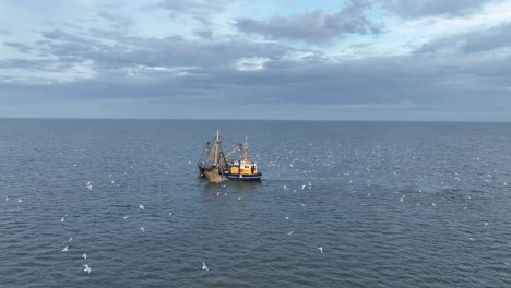 Schwenk-Drohnenaufnahme-Eines-Fischerboots,-Das-Die-Netze-Durch-Das-Wasser-Zieht