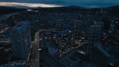 Downtown-with-modern-business-offices-and-apartment-houses-at-night---aerial-drone-view