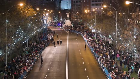 Police-officers-secure-the-road-ahead-for-the-Three-Wise-Men-festival,-also-known-as-the-Three-Kings-Parade,-a-family-spectacle-featuring-floats-with-wise-men,-dancers,-musicians,-and-candy-giveaways