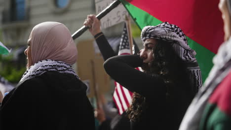 Una-Mujer-Joven-Con-Una-Keffiyeh-Sostiene-Una-Bandera-Palestina-Y-Grita-Entre-La-Multitud-En-La-Marcha-En-Washington.