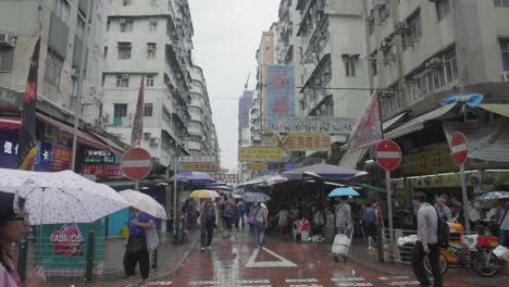 Mong-Kok-Bereich-Von-Hong-Kong-Street-Market-Voller-Händler-Und-Fußgänger-Mit-Sonnenschirmen-An-Einem-Regnerischen-Tag
