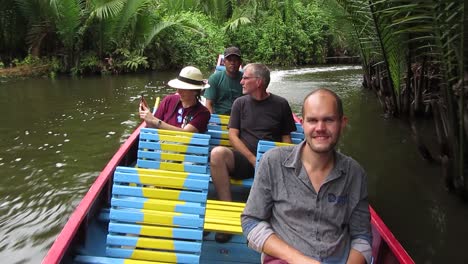 Foreign-tourists-boarding-a-traditional-boat-visit-the-geological-site-in-Ramang-Ramang-village,-Maros,-South-Sulawesi,-Indonesia