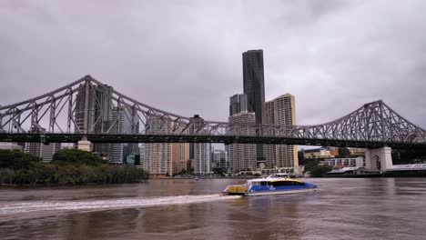 Weite-Aufnahme-Einer-Fähre,-Die-Vor-Der-Story-Bridge-Vorbeifährt,-Und-Brisbane-City,-Gesehen-Vom-New-Farm-River-Walk