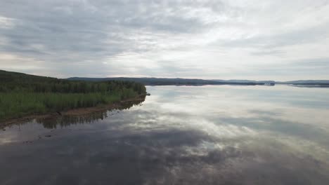 Aerial-shot-of-Sweden-lake-with-trees-at-a-side-during-daytime-in-Sweden