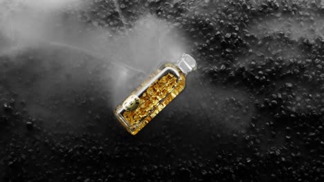 Bottle-of-24k-Gold-bottle-on-black-rock-background-is-surrounded-by-a-milky-white-haze
