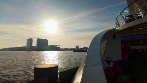 Dutch-Amsterdam-ferry-on-IJ-river-with-sun-and-backlight-reflection-in-water