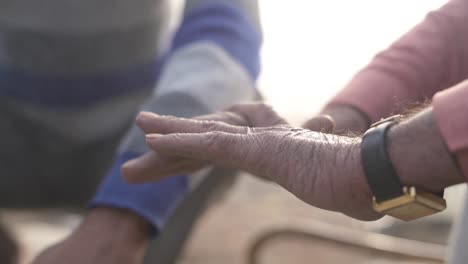 Static-shot-of-a-hand-of-an-Old-south-asian-indian-man-enjoying-wood-fire-heat-during-a-winter-morning-in-india