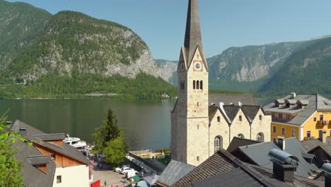 Hallstatt-Kirche-Mit-Blick-Auf-Den-See,-Während-Menschen-Um-Ihn-Herumgehen