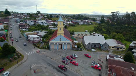 órbita-Aérea-Estableciendo-La-Iglesia-Patrimonial-De-Chonchi-En-Chiloé,-Chile-Con-Un-Horizonte-Soleado-Con-Nubes