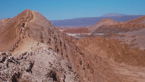 Gente-Caminando-Por-Un-Sendero-De-Roca-Roja-En-El-Desierto-Durante-El-Día