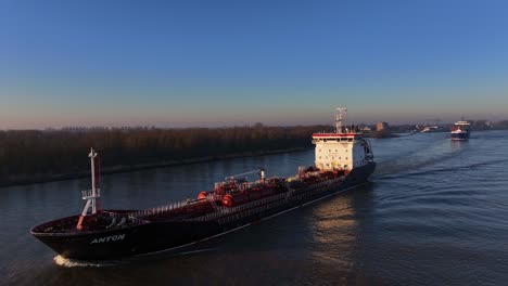Tanker-navigating-at-a-dutch-river-at-sunrise