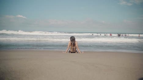 Frau-Im-Bikini-Entspannt-Am-Strand-Mit-Meereswellen,-Die-über-Sie-Hinwegrollen