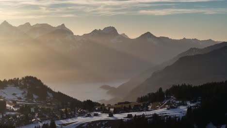 Sunset-glow-over-snowy-Walensee,-Glarus,-Switzerland---aerial-panoramic