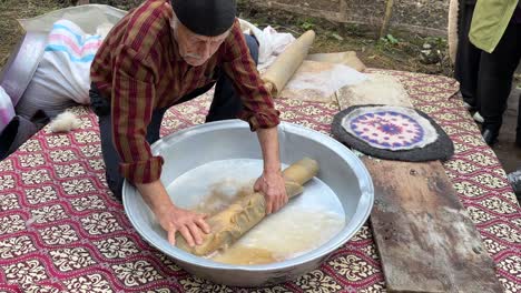 Viejo-Artista-Hombre-Retorciendo-Estera-De-Lana-Material-De-Fibra-De-Lana-Alfombra-Tradicional-En-Irán-Cultura-Persa-De-Habilidad-Artesanal-Hecha-A-Mano-En-El-Centro-Rural-Histórico-Antiguo-Taller-Cultura-De-Diseño-Colorido