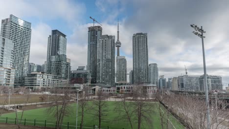 Sports-field,-skyscrapers-and-cranes-in-cloudy-Toronto,-timelapse