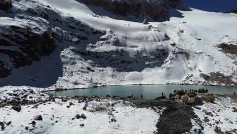 Offene-Wasserlagune-Auf-Schneebedeckten-Alpinen-Berghängen,-Laguna-Charquini-Bol