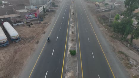 Biker,-Der-In-Der-Abenddämmerung-Den-Punjab-Highway-Entlang-Fährt---Luftaufnahme