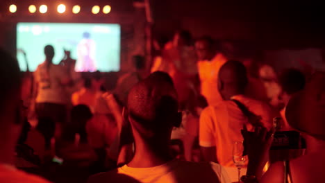 Aficionados-Al-Fútbol-De-Costa-De-Marfil-Viendo-Alegremente-Un-Partido-En-Una-Zona-De-Aficionados,-Copa-Africana-De-Naciones-2023,-Abidjan