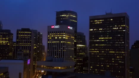 Aerial-rising-shot-toward-the-illuminated-US-bank-office,-night-in-San-Francisco