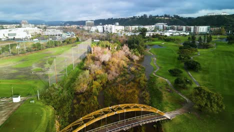 Aerial-view-of-river-overflowing-into-a-golf-course