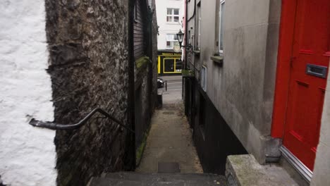 Eine-POV-Aufnahme-Eines-Spaziergangs-Durch-Eine-Schmale-Gasse-Zwischen-Gebäuden-In-Der-Stadt-Dublin,-Irland