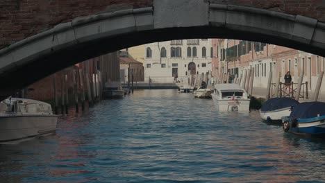 Vista-Del-Canal-Veneciano-Bajo-Un-Puente-De-Arco,-Aguas-Serenas.