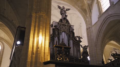 Escénica-Toma-Interior-Arquitectónica-De-La-Iglesia,-Arcos-Góticos,-Lámpara-De-Araña-Con-Estatua-De-Un-ángulo