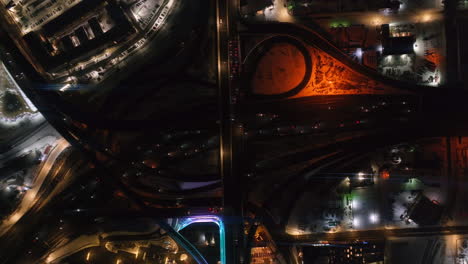 Downtown-Denver-i25-traffic-highway-Birds-Eye-view-snowy-winter-evening-night-city-lights-landscape-aerial-drone-cinematic-anamorphicColorado-Mile-High-DU-Metro-Eltiches-Empower-Field-Ball-Arena-up