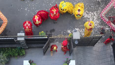 Year-of-Dragon-dance-performance-in-a-small-street-in-Ho-Chi-Minh-City,-Vietnam-from-top-down-view