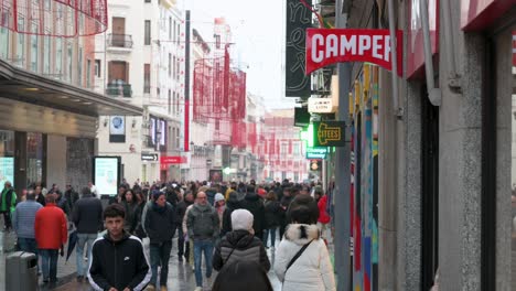 En-Una-Bulliciosa-Calle-Comercial,-Los-Compradores-Entran-En-La-Tienda-Camper,-Una-Multinacional-Española-Especializada-En-La-Fabricación-Y-Venta-Minorista-De-Calzado,-Ubicada-En-Madrid,-España.