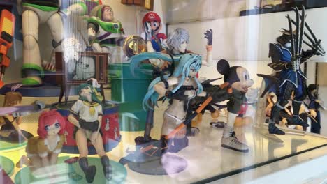 Anime-manga-Japanese-and-Chinese-plastic-sexy-dolls-in-storefront-of-shop-in-Shanghai,-China,-panning-shot