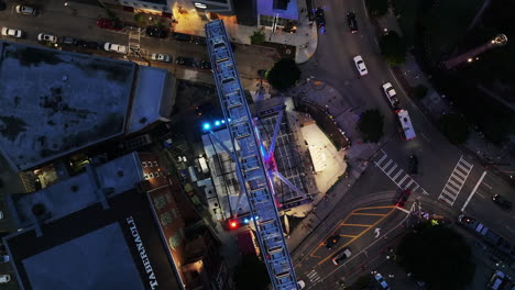 Von-Oben-Nach-Unten-Rotierende-Aufnahme-Des-Riesenrads-Und-Der-Umliegenden-Gebäude-Im-Stadtbezirk-In-Der-Abenddämmerung