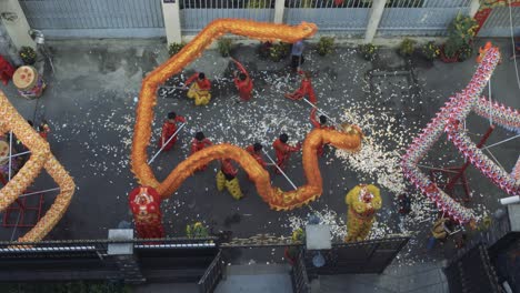 Year-of-Dragon-dance-performance-in-a-small-street-in-Ho-Chi-Minh-City,-Vietnam-from-top-down-view