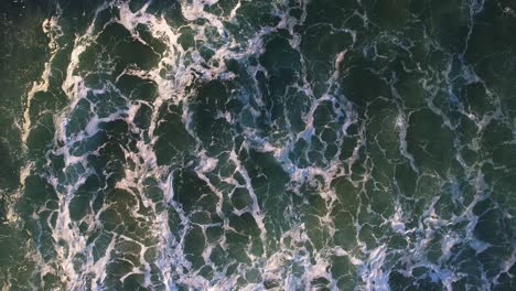 Wirbelnde-Meereswellen-Erzeugen-Türkisfarbene-Strukturmuster-Mit-Weißem-Wasserschaum-In-Zeitlupe