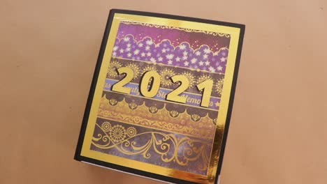 Vintage-Styled-2021-Scrapbook-with-Cool-Paper-Spinning-on-Wooden-Surface