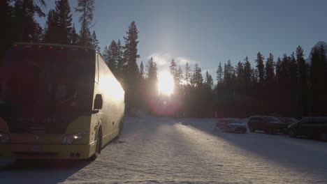 Passagierbus-Auf-Verschneiten-Parkplatz-Sonne-Im-Gegenlicht