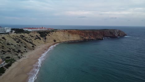 Drone-shot-of-a-landscape-with-a-5-star-Hotel-on-the-shore-in-Portugal-facing-the-atlantic-ocean