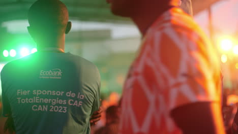 Ivorian-Men-Wearing-Ecobank-Shirts-Watching-A-Match,-Africa-Cup-of-Nations-2023,-Abidjan