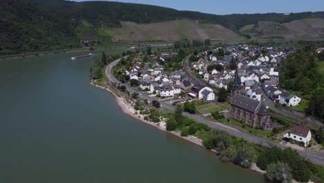 Schiffe-Passieren-Ein-Deutsches-Dorf-Am-Flussufer-Der-Großen-Rheinschleife-Von-Boppard,-Luftaufnahme