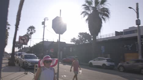 Middle-aged-white-woman-walking-out-on-street-in-Venice-Beach,-California
